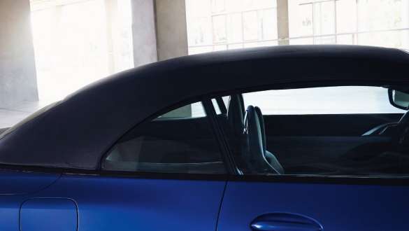 Softtop BMW M4 Competition Convertible with M xDrive G83 2021 BMW M4 Competition Convertible with M xDrive G83 2021 BMW Individual Frozen Portimao Blue metallic with closed softtop and man in front