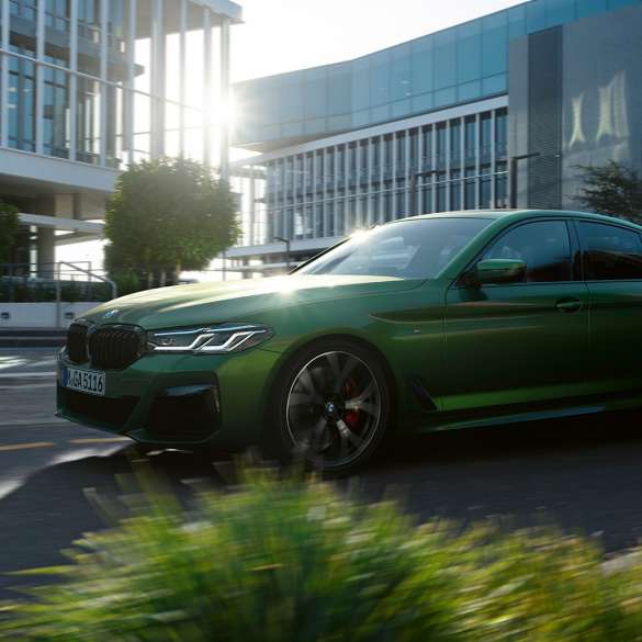 BMW M550i xDrive Sedan G30 LCI Facelift 2020 side view driving BMW M550i xDrive Sedan G30 LCI Facelift 2020 BMW Individual Verde Ermes metallic side view driving downtown