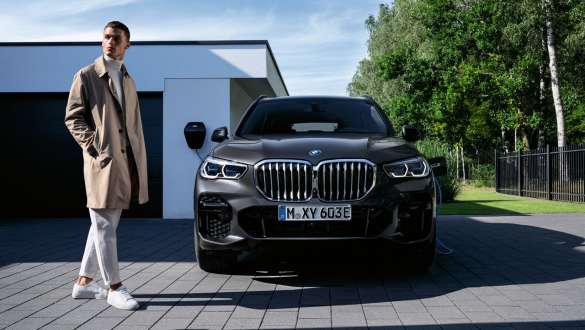 Plug-in hybrid BMW X5 xDrive45e G05 front view in front of garage Plug-in hybrid BMW X5 xDrive45e G05 front view in front of garage with model