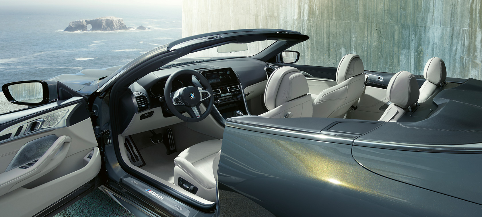 BMW M850i xDrive Dravit Grey metallic, side view, soft top and door open. BMW M850i xDrive Dravit Grey metallic, side view, soft top and door open.