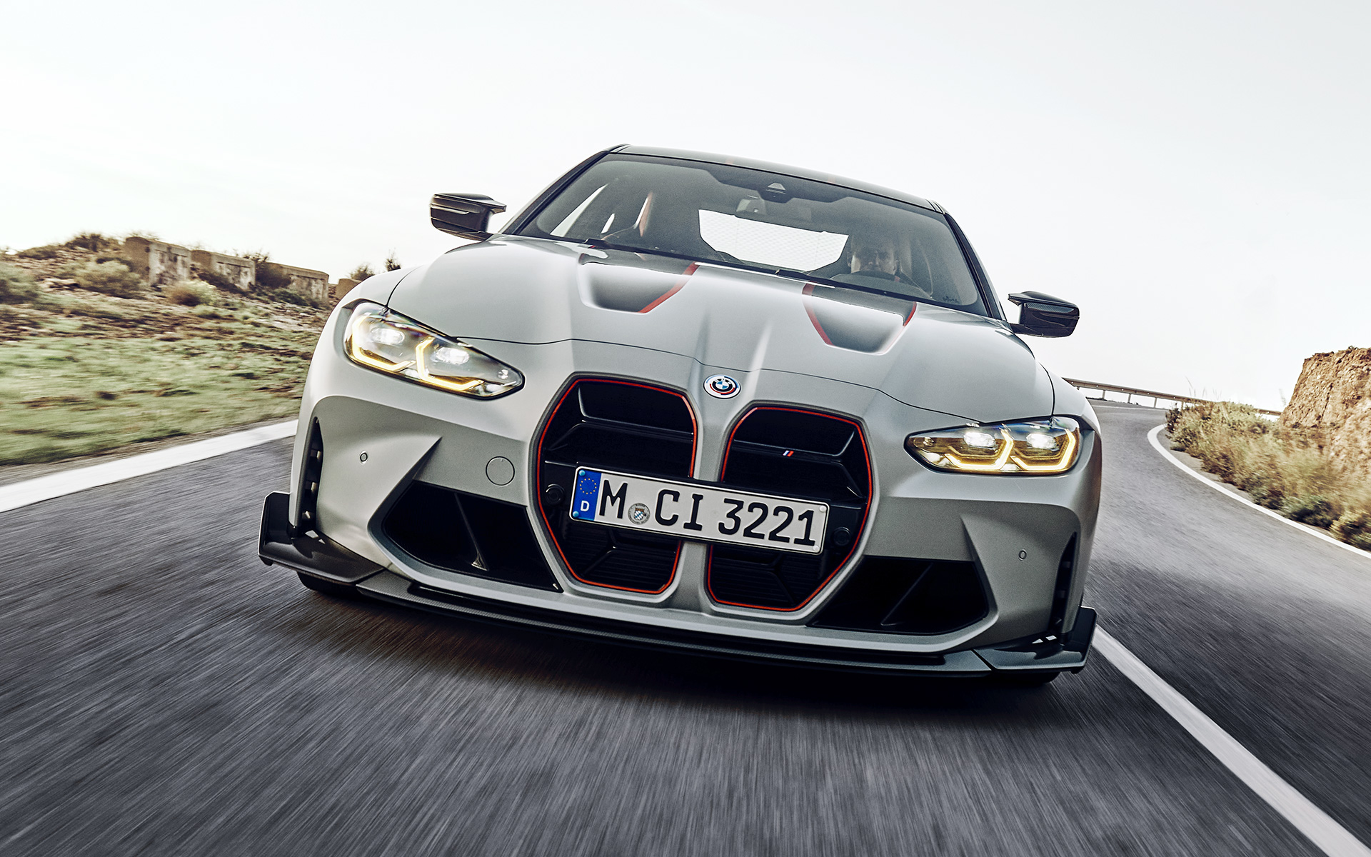 Kidney grill slats in Black with signature foil wrapping in Red BMW M4 CSL G82 BMW M4 CSL G82 BMW Individual Frozen Brooklyn Grey metallic Kidney grill slats in Black with signature foil wrapping in Red front view driving on the street