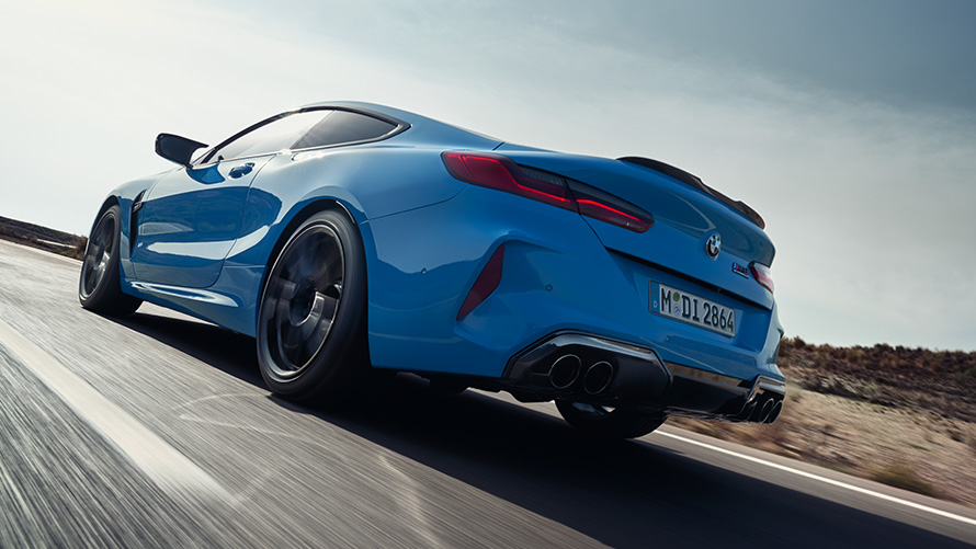 BMW M8 Competition Coupé F92 LCI Facelift 2022 Daytona Beach blue uni three-quarter rear view driving on a highway