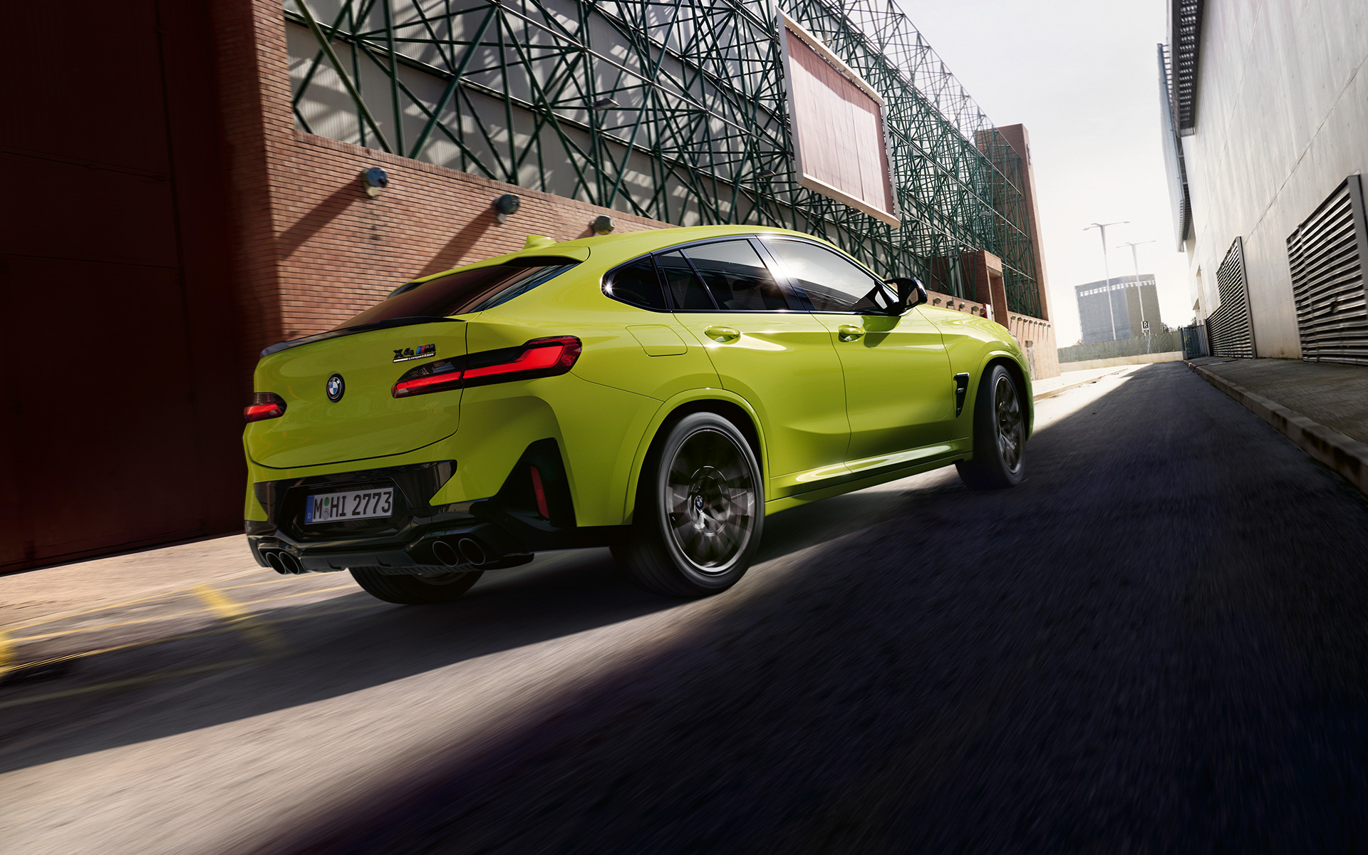 BMW X4 M Competition F98 LCI Facelift 2021 Sao Paulo Yellow three-quarter front view driving between factory buildings