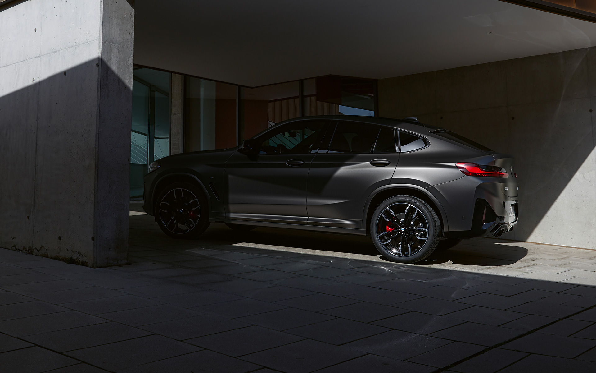 BMW X4 M40i G02 LCI 2021 Facelift side view half in the shade in front of a house entrance