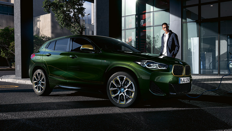 BMW X2 F39 Sanremo Green metallic Three-quarter side view with model BMW X2 F39 Sanremo Green metallic Three-quarter side view with model