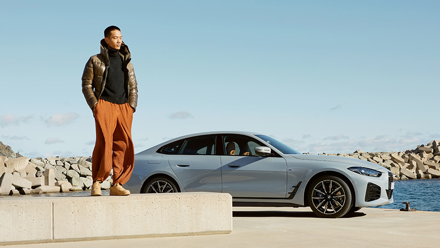 BMW Service Inclusive man in front of BMW i4 on the coast